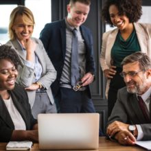 People Crowded Around Laptop At Work